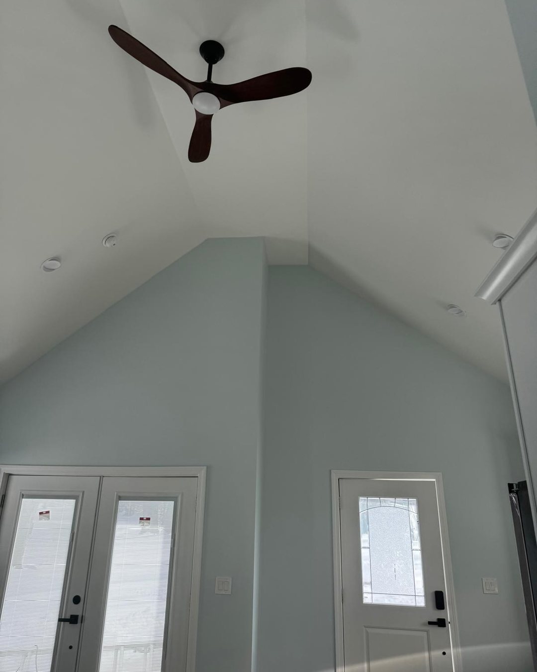 The same gable wall finished in pale blue with a vaulted white ceiling and ceiling fan