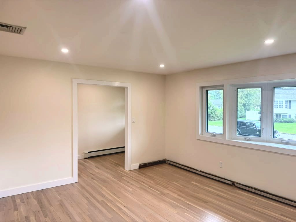 Living room with bay window and wide cased opening