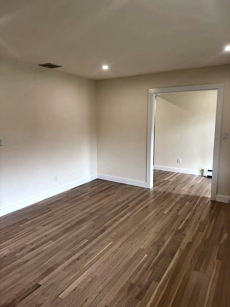 Living room with a wide cased opening and refinished oak floor