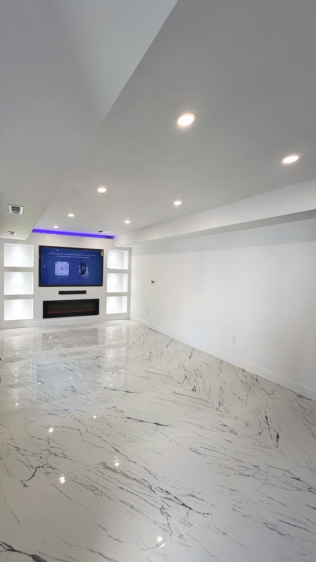 Finished media room with glossy marble-look tile floor