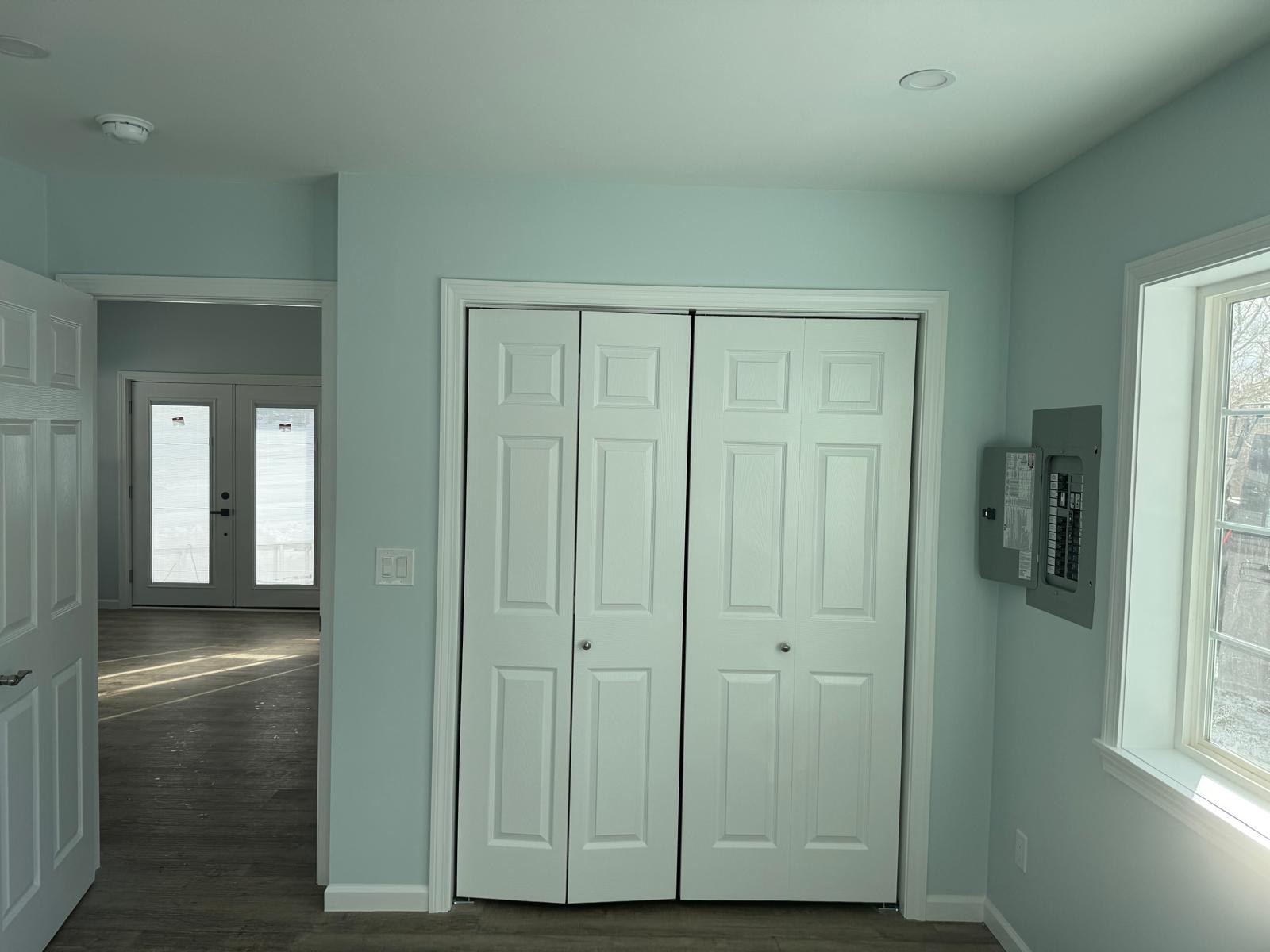 Bedroom with white bifold closet doors and pale blue walls