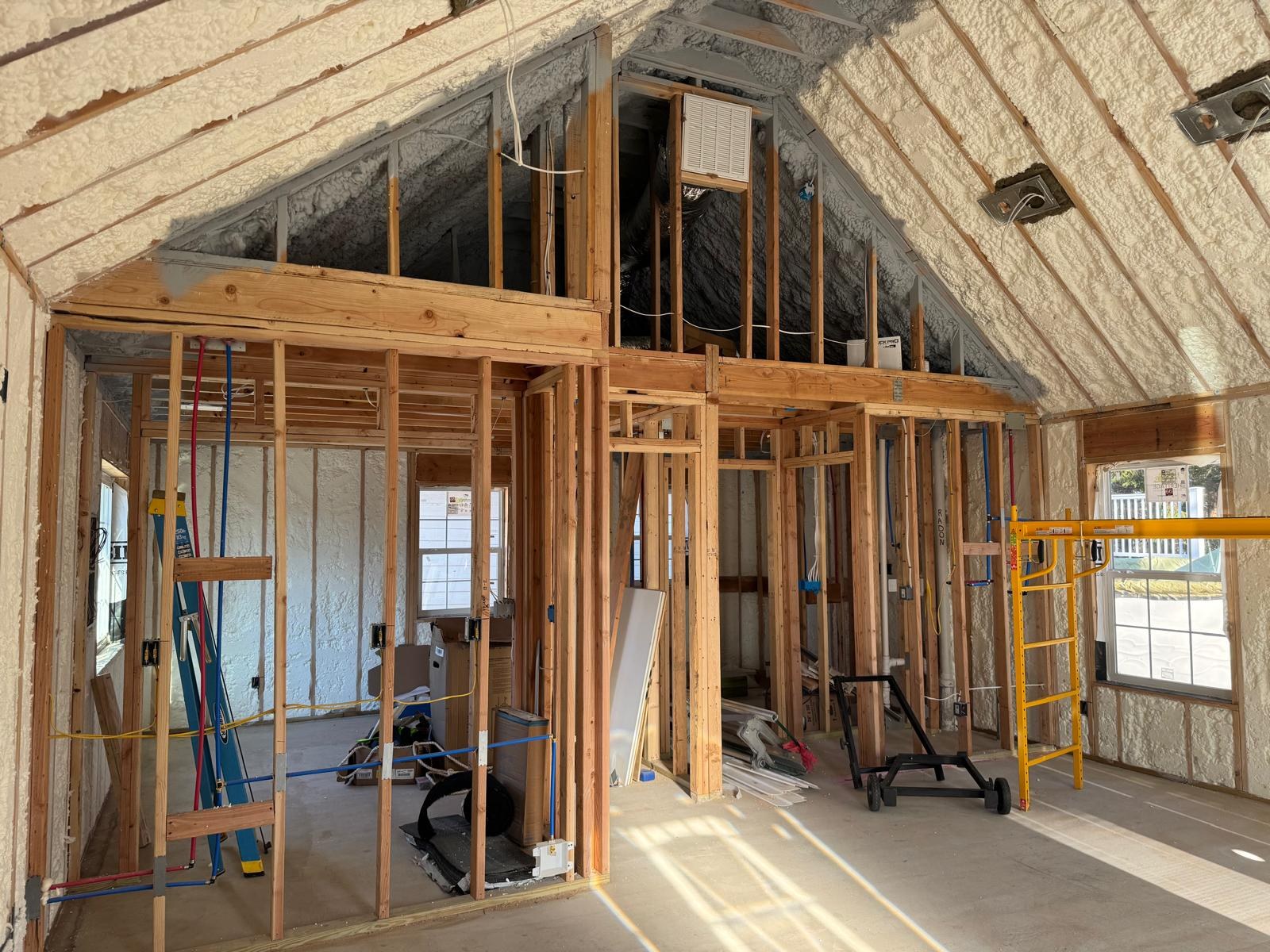 Interior framing with plumbing and wiring roughed in under a spray-foamed vaulted roof