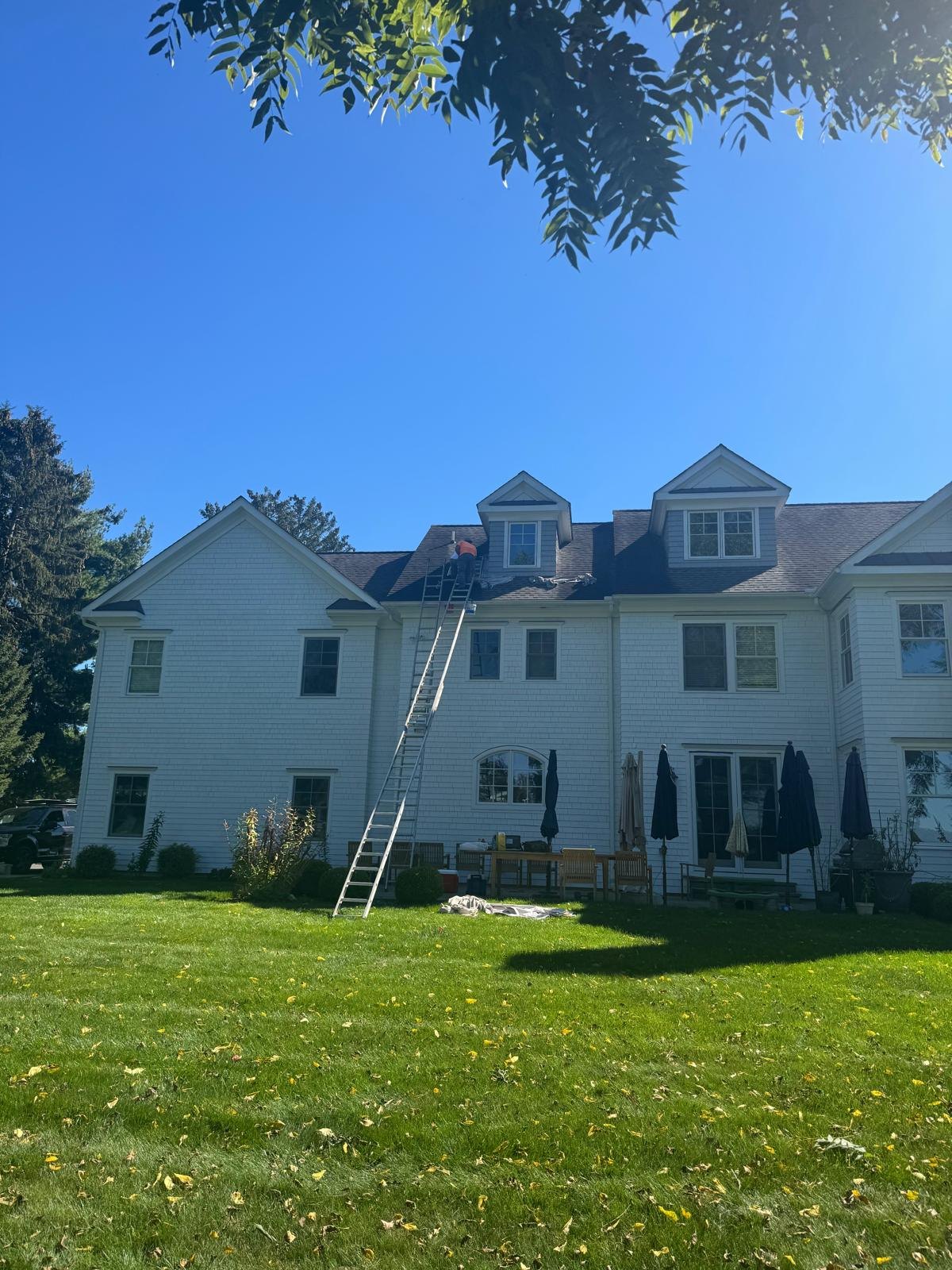 Back of the house painted white, with a ladder up to the dormers