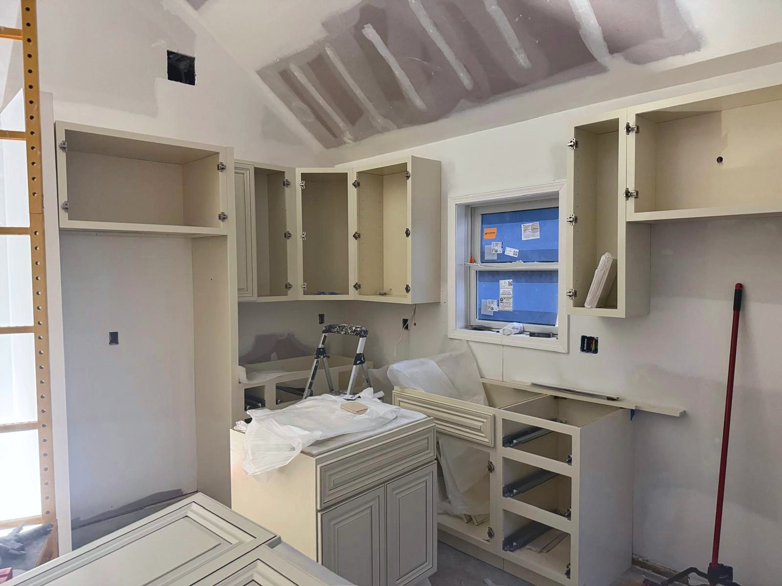 Cream kitchen cabinets going in under the vaulted ceiling