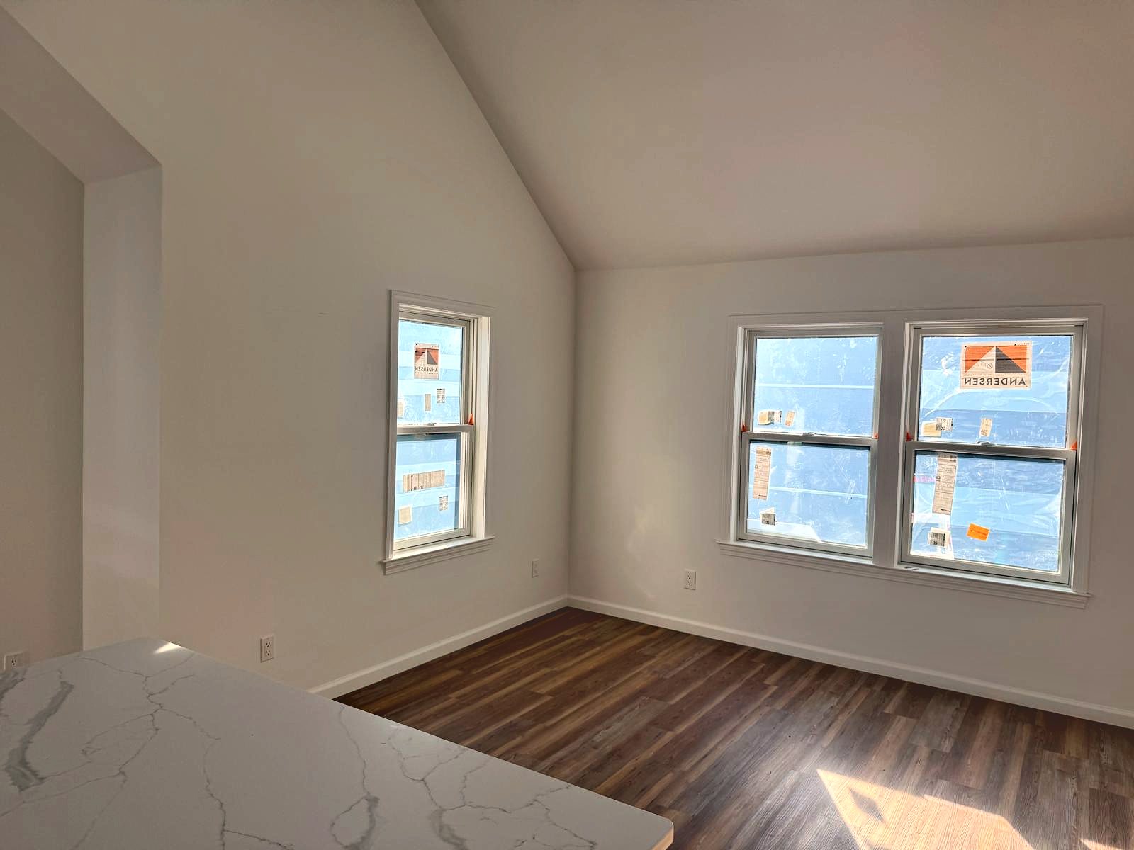 Vaulted living area with new windows and plank flooring